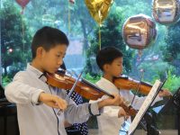 圖一、七歲小提琴手陳如恩及十歲小提琴手陳如一為長輩獻曲，與長輩一搭一唱，老幼共融為生命故事音樂會添加活力與溫馨色彩。